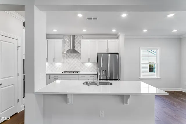 a kitchen with kitchen island a sink stainless steel appliances and cabinets