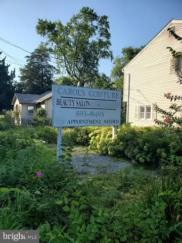 a view of sign board with yard and wooden fence