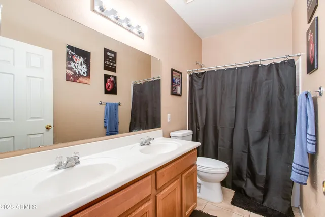 a bathroom with a double vanity sink toilet and shower