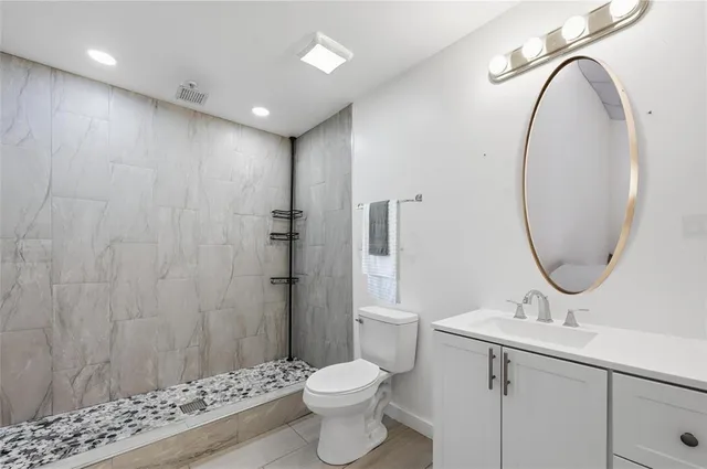 a bathroom with a toilet a sink and a mirror