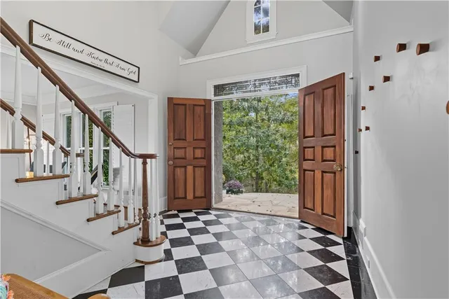 a living room with furniture a flat screen tv and floor to ceiling window