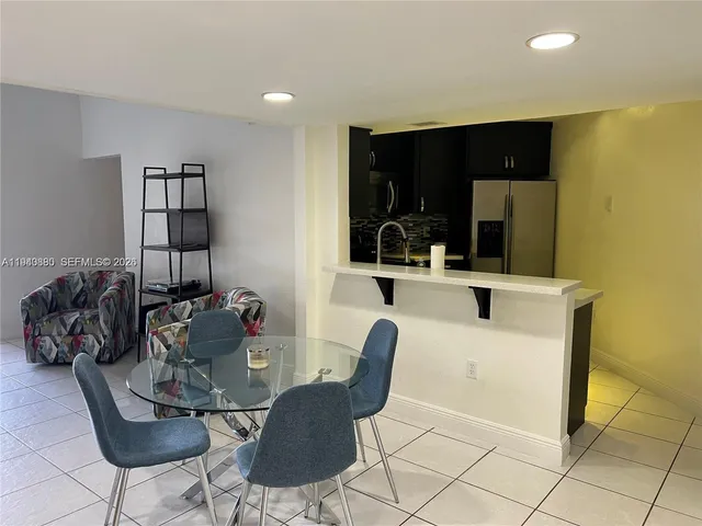 a living room with furniture and kitchen view