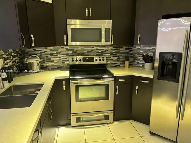 a kitchen with stainless steel appliances a stove a microwave and sink