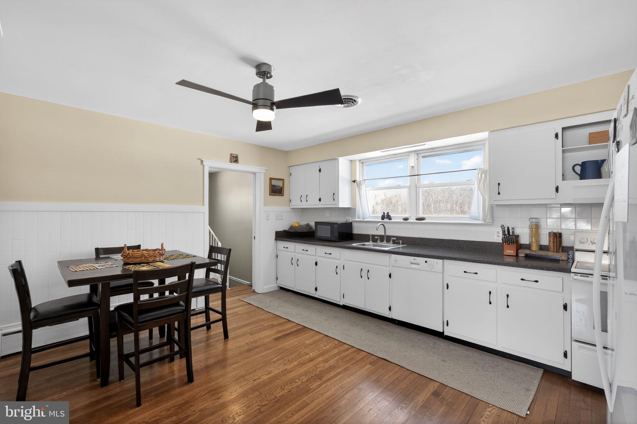 110 Landing Street Southampton, NJ 08088 - Photo 13 of 30 a kitchen with granite countertop a table chairs wooden floors and a view of living room
