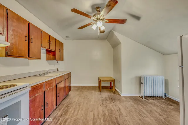 a view of a kitchen with a sink and wooden floor