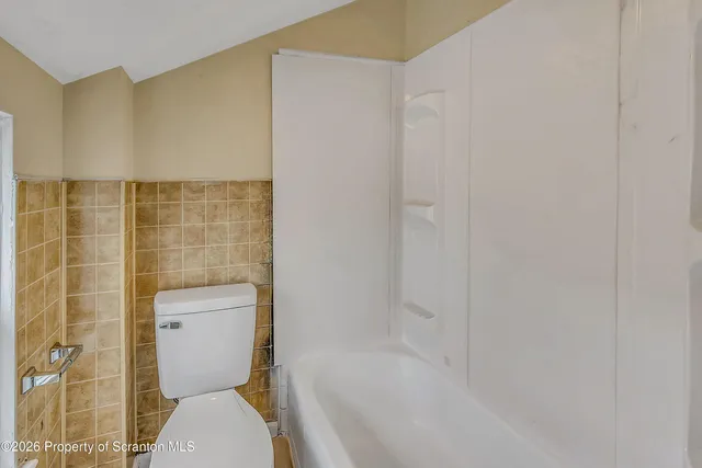 a bathroom with a toilet and shower