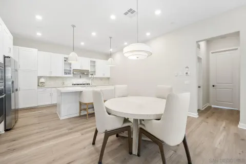 a kitchen with kitchen island a dining table and chairs