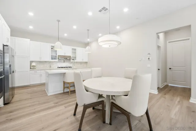 a kitchen with kitchen island a dining table and chairs