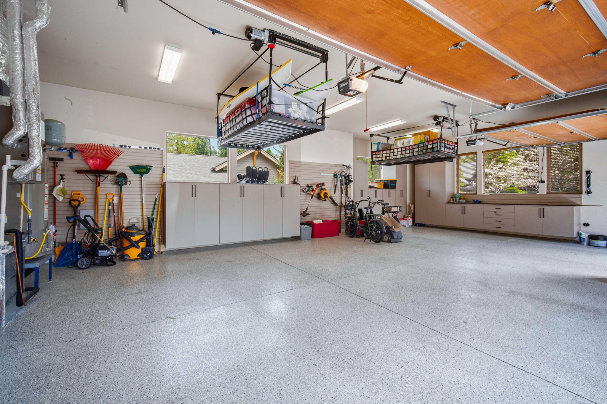56328 Fireglass Loop Bend, OR 97707 - Photo 49 of 72 Oversized 3 car garage with epoxy flooring, custom cabinets and two electric lifts for storing your toys and seasonal items.
