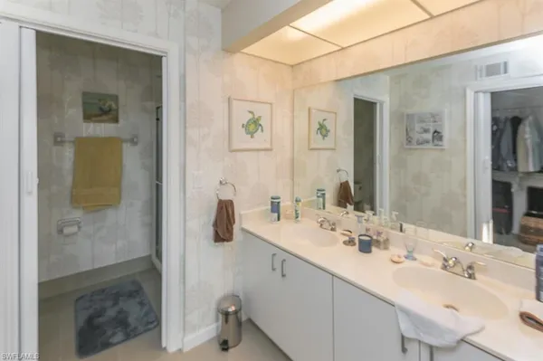 a bathroom with a double vanity sink mirror and shower