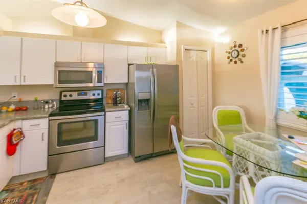 a kitchen with stainless steel appliances kitchen island granite countertop a refrigerator and microwave