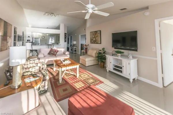 a living room with furniture a flat screen tv and a floor to ceiling window