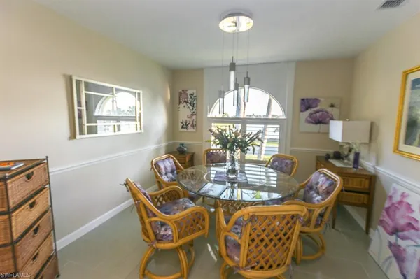 a dining room with furniture a chandelier and window