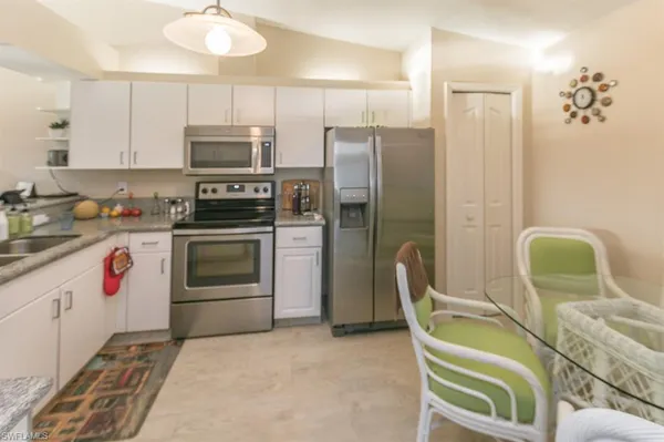 a kitchen with stainless steel appliances granite countertop a stove a refrigerator and a microwave