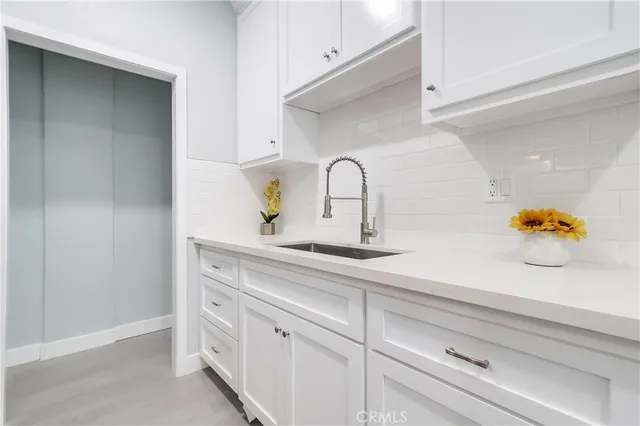 a kitchen with white cabinets and a sink