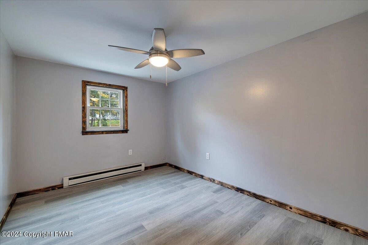 1456 Allegheny Drive Blakeslee, PA 18610 - Photo 20 of 94 an empty room with wooden floor chandelier fan and windows