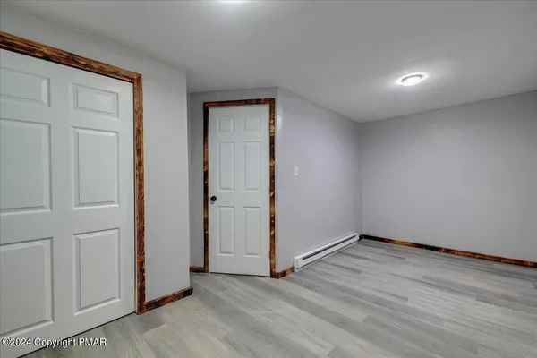 a backyard of a house with plants and large tree