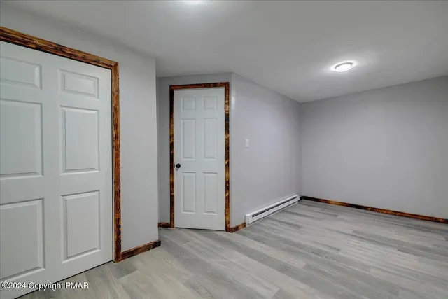 a backyard of a house with plants and large tree