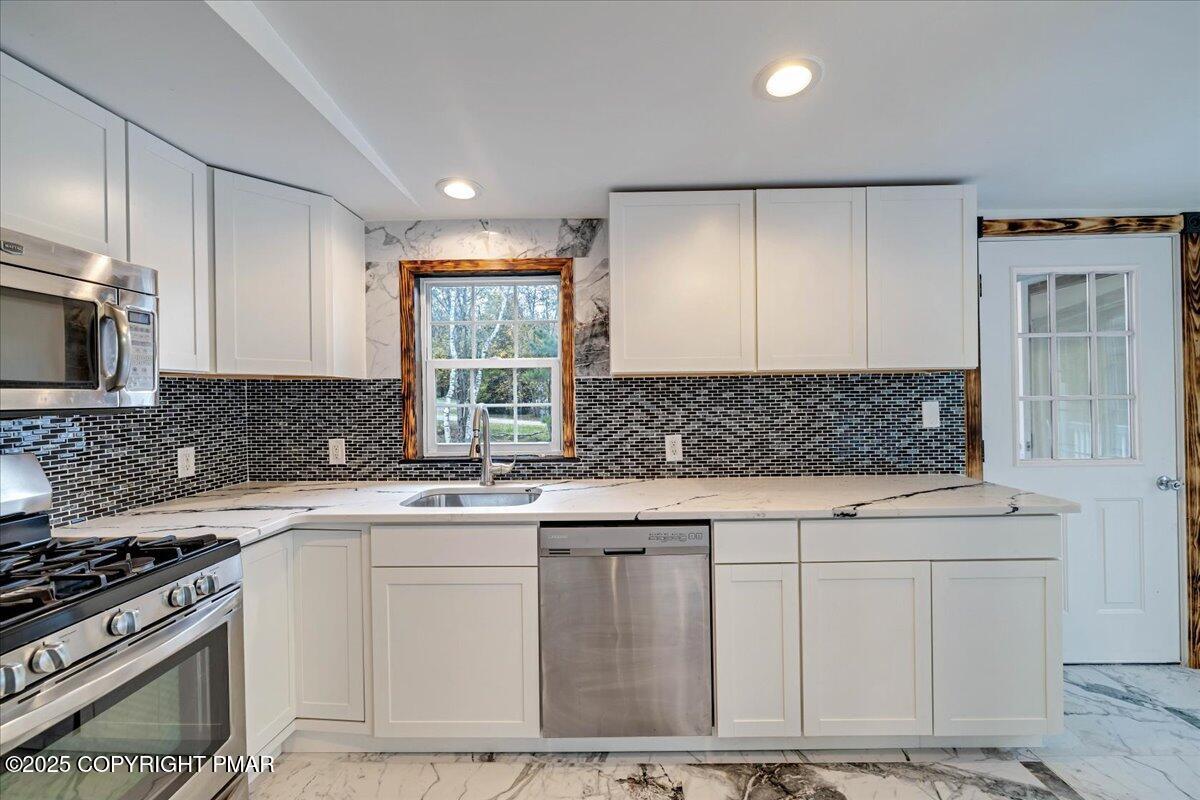 1456 Allegheny Drive Blakeslee, PA 18610 - Photo 79 of 94 a kitchen with stainless steel appliances granite countertop a stove a sink and a microwave