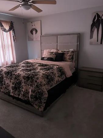 a bed sitting in a bedroom next to a window and a chandelier