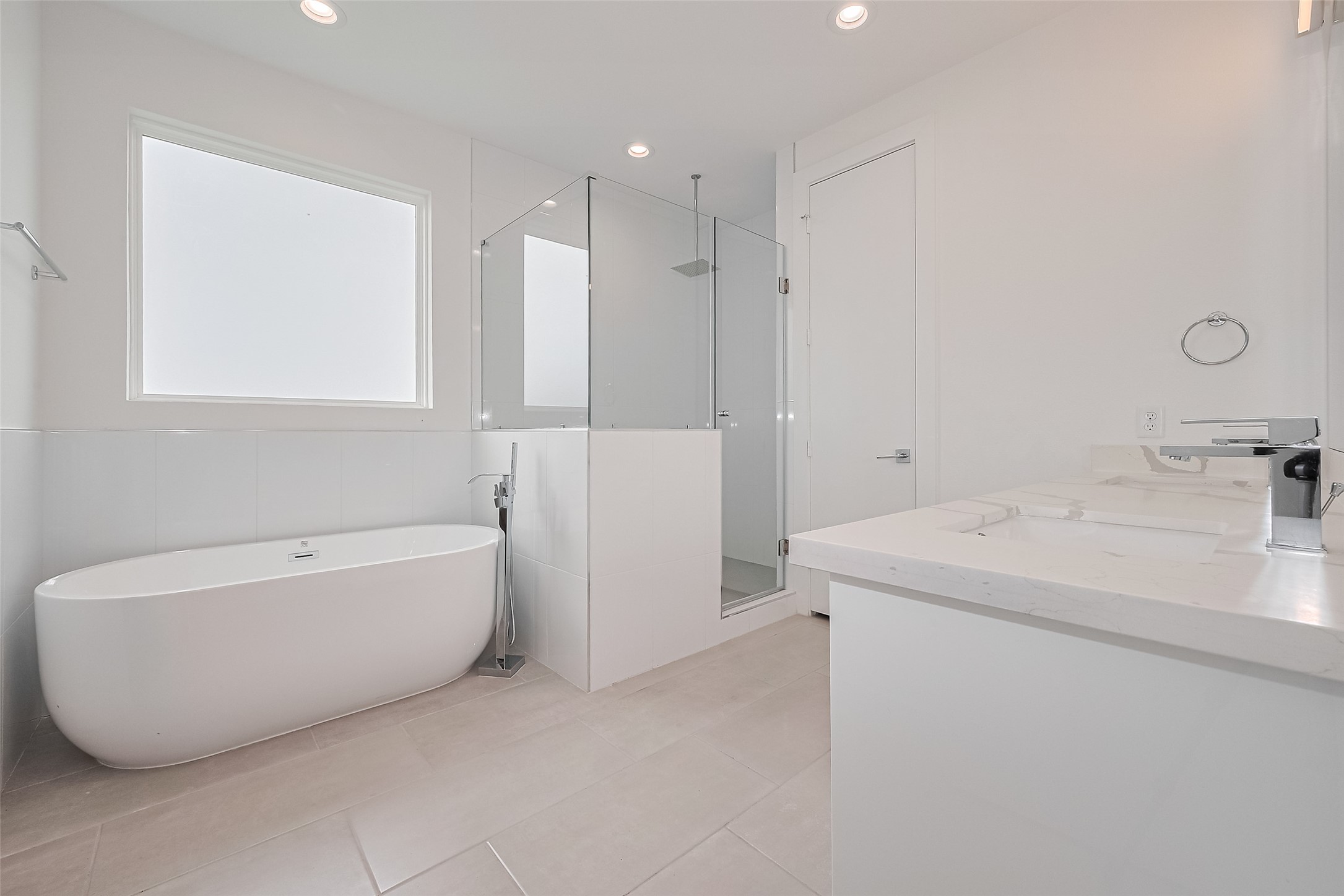 3510 Hadley Street Houston, TX 77004 - Photo 40 of 48 Unwind in the luxe primary bath with a soaking tub set beneath a frosted window, a glass-enclosed shower, and a double-sink vanity. Clean lines, modern lighting, and generous storage create a spa-like ambiance.