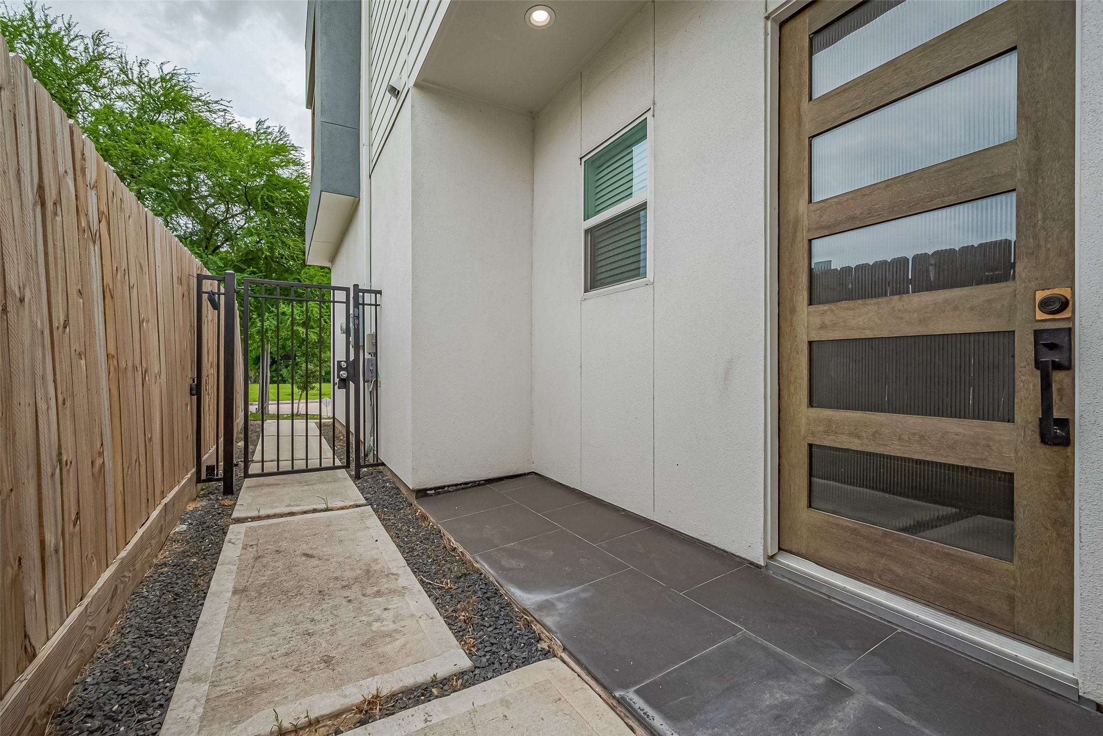 3510 Hadley Street Houston, TX 77004 - Photo 7 of 48 A closer look reveals the front door subtly tucked to the side, accessed through a gated walkway. The contemporary door design—featuring horizontal glass panels—hints at the thoughtful details found throughout the home.