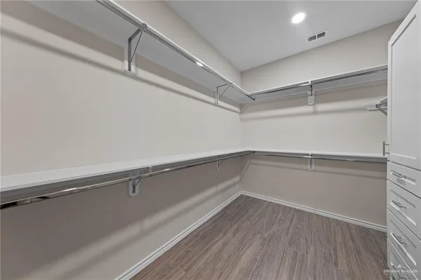 a view of walk in closet with empty racks