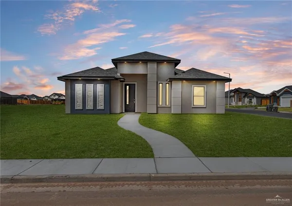 a front view of a house with a garden and yard