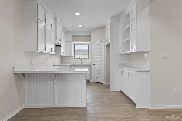 a kitchen with white cabinets and sink