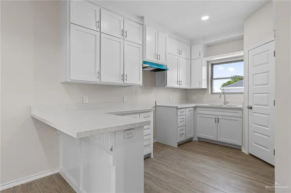 a kitchen with white cabinets and a sink