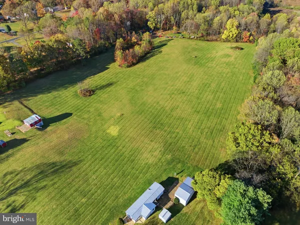 an aerial view of a residential houses with yard