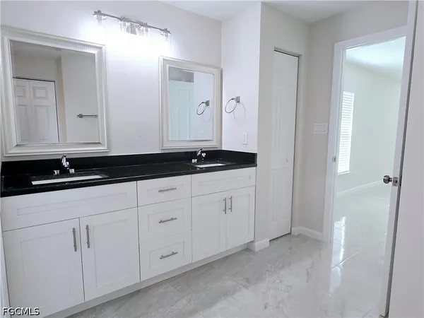 a bathroom with white cabinets