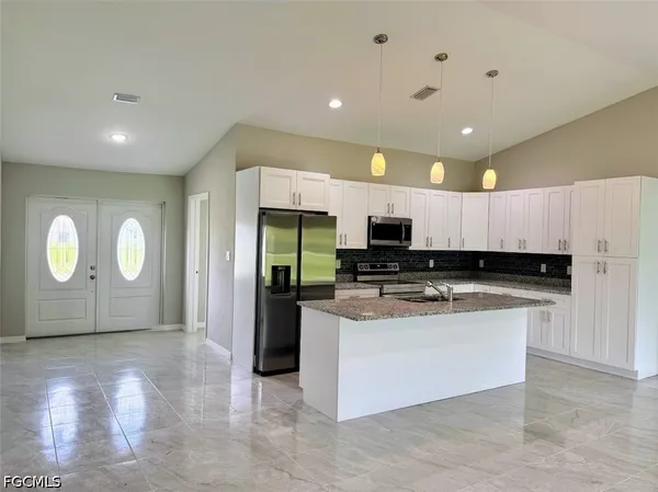 a kitchen with stainless steel appliances granite countertop a stove a sink and a refrigerator
