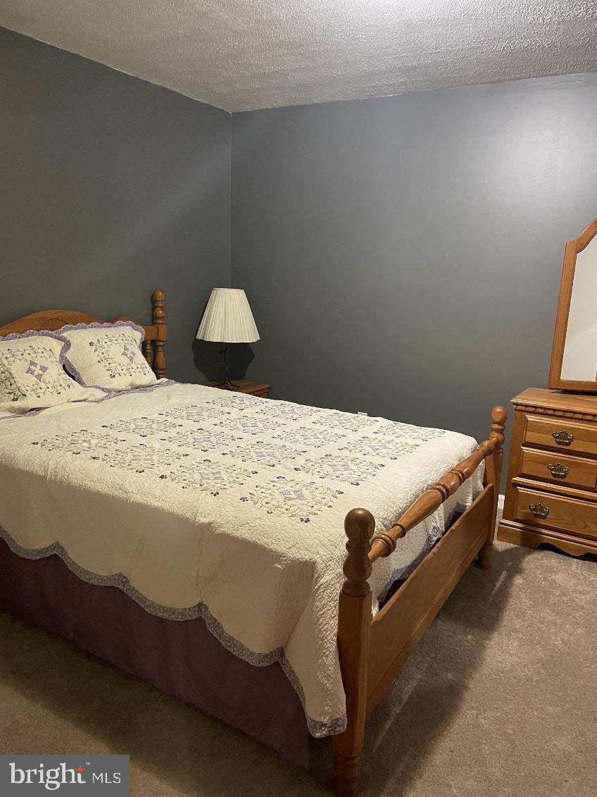 12632 Western Circle Lusby, MD 20657 - Photo 6 of 8 a bedroom with a bed and lamp