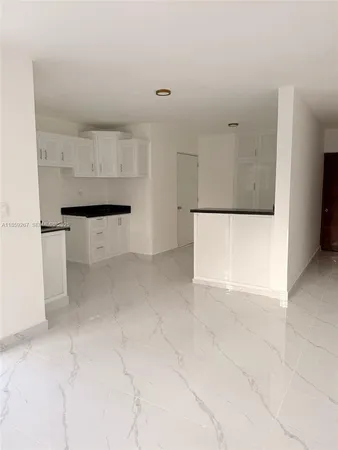 a view of kitchen with furniture and refrigerator
