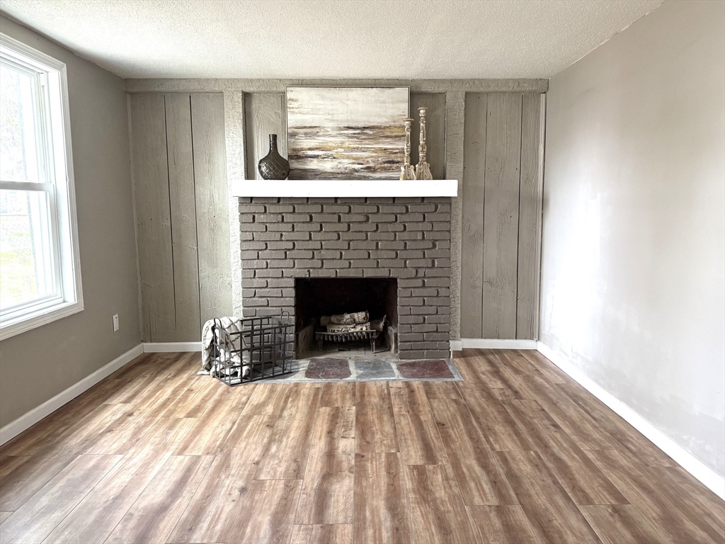 511 Parker Street Springfield, MA 01129 - Photo 12 of 41 a view of empty room with wooden floor and fireplace