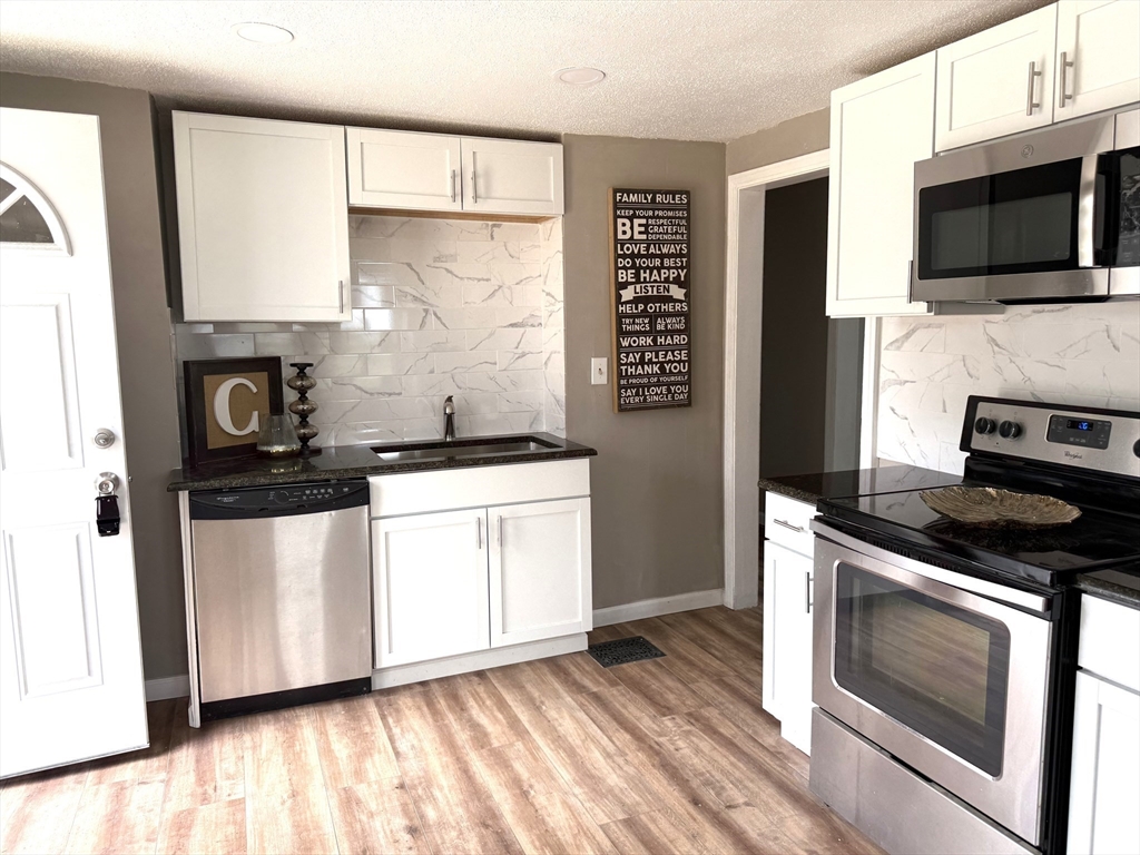511 Parker Street Springfield, MA 01129 - Photo 4 of 41 a kitchen with granite countertop a sink and steel appliances