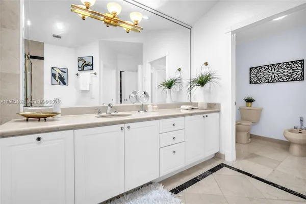 a bathroom with a double vanity sink a toilet and a mirror
