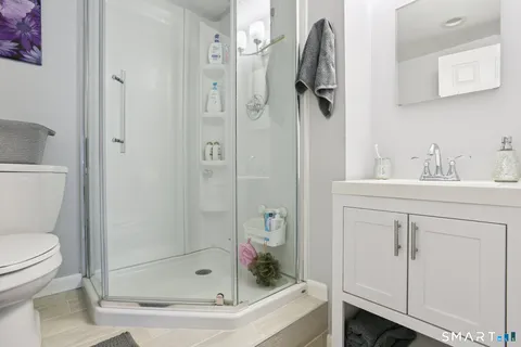 a bathroom with a shower a sink and toilet