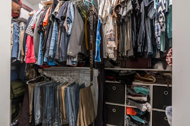 a view of walk in closet with clothes and shoes