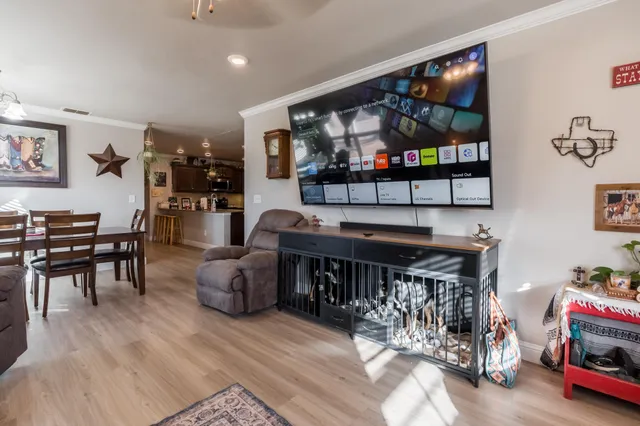 a living room with furniture a flat screen tv and a floor to ceiling window