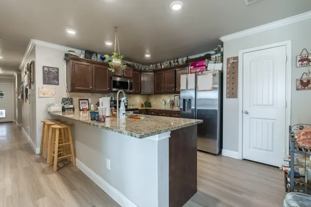 a kitchen with kitchen island granite countertop a sink stove and refrigerator