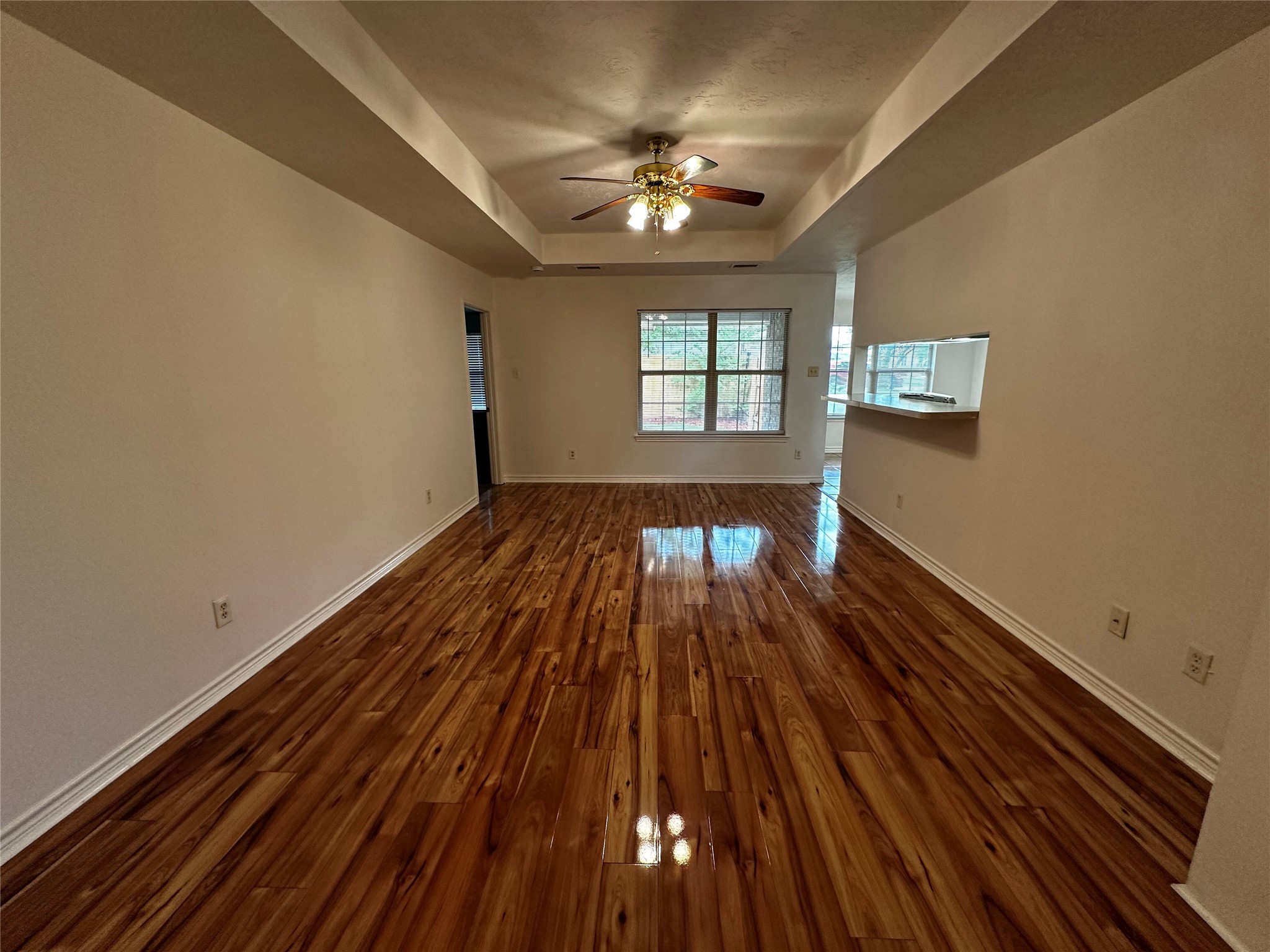 1400 Prairie Drive Bryan, TX 77802 - Photo 4 of 18 Hardwood flooring extends through this open-concept living space, featuring high ceilings and a ceiling fan.