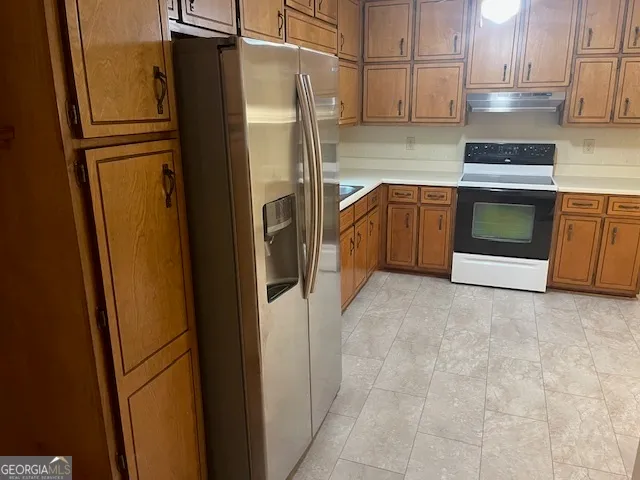 a kitchen with stainless steel appliances granite countertop a refrigerator and a stove