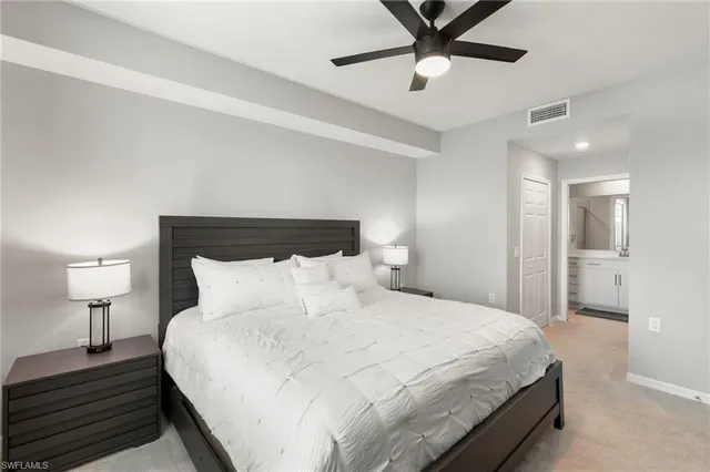 a bedroom with a bed and a lamp on a dresser