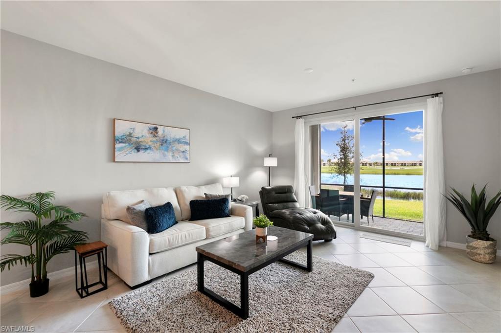 43993 Boardwalk Loop, Unit 1914 Punta Gorda, FL 33982 - Photo 8 of 36 Living room featuring light tile patterned floors and a water view