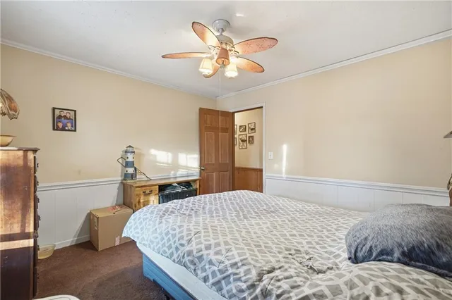 a bedroom with a bed and a ceiling fan