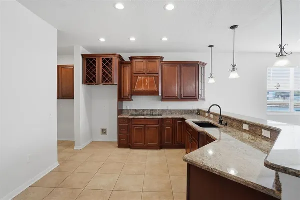 a kitchen with stainless steel appliances granite countertop a sink refrigerator and cabinets