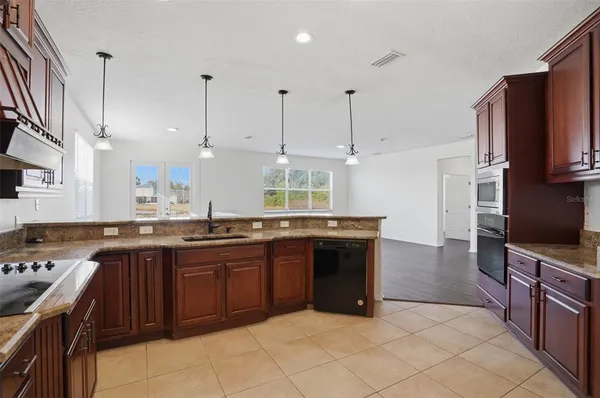a kitchen with stainless steel appliances granite countertop a stove a sink and a refrigerator