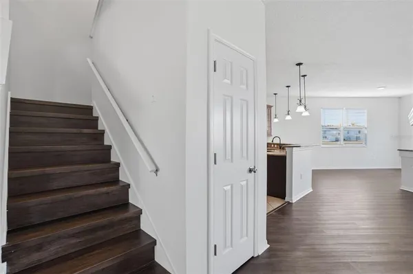 a view of a hallway with wooden floor and staircase